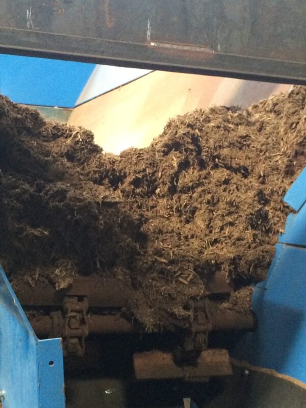 A pile of dirt in the middle of a blue machine.