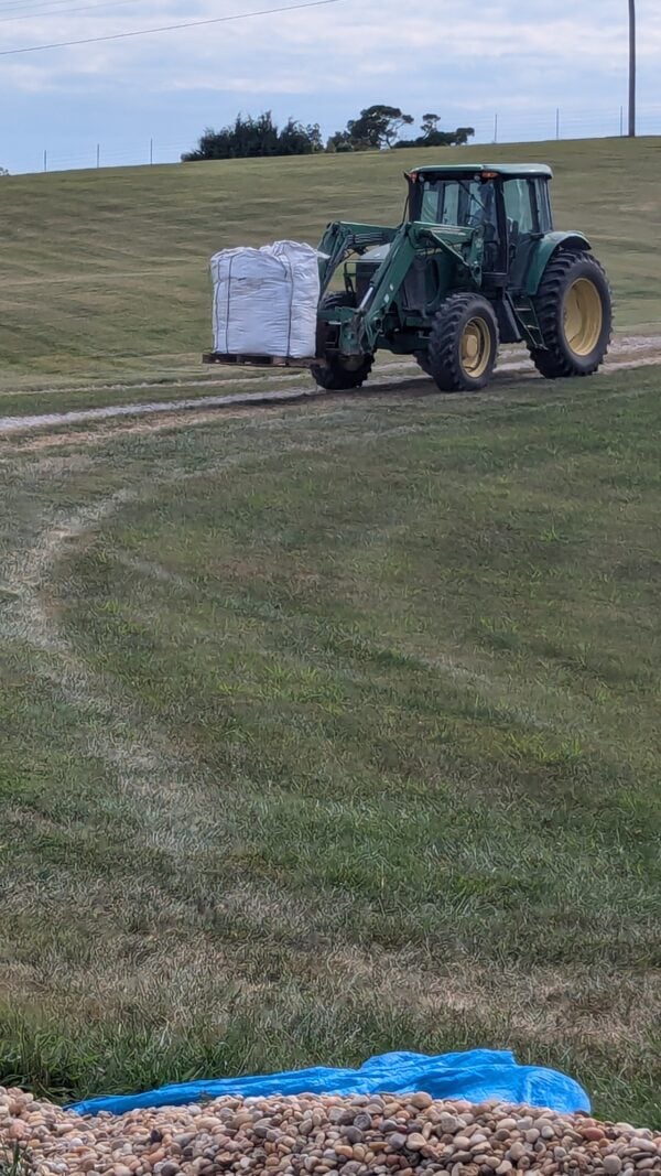 A tractor is pulling a trailer in the middle of a field.