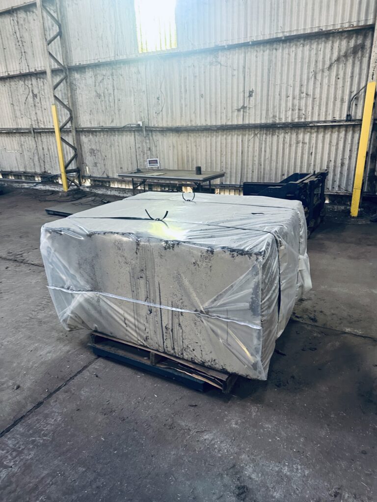 A large box wrapped in plastic and sitting on top of a pallet.