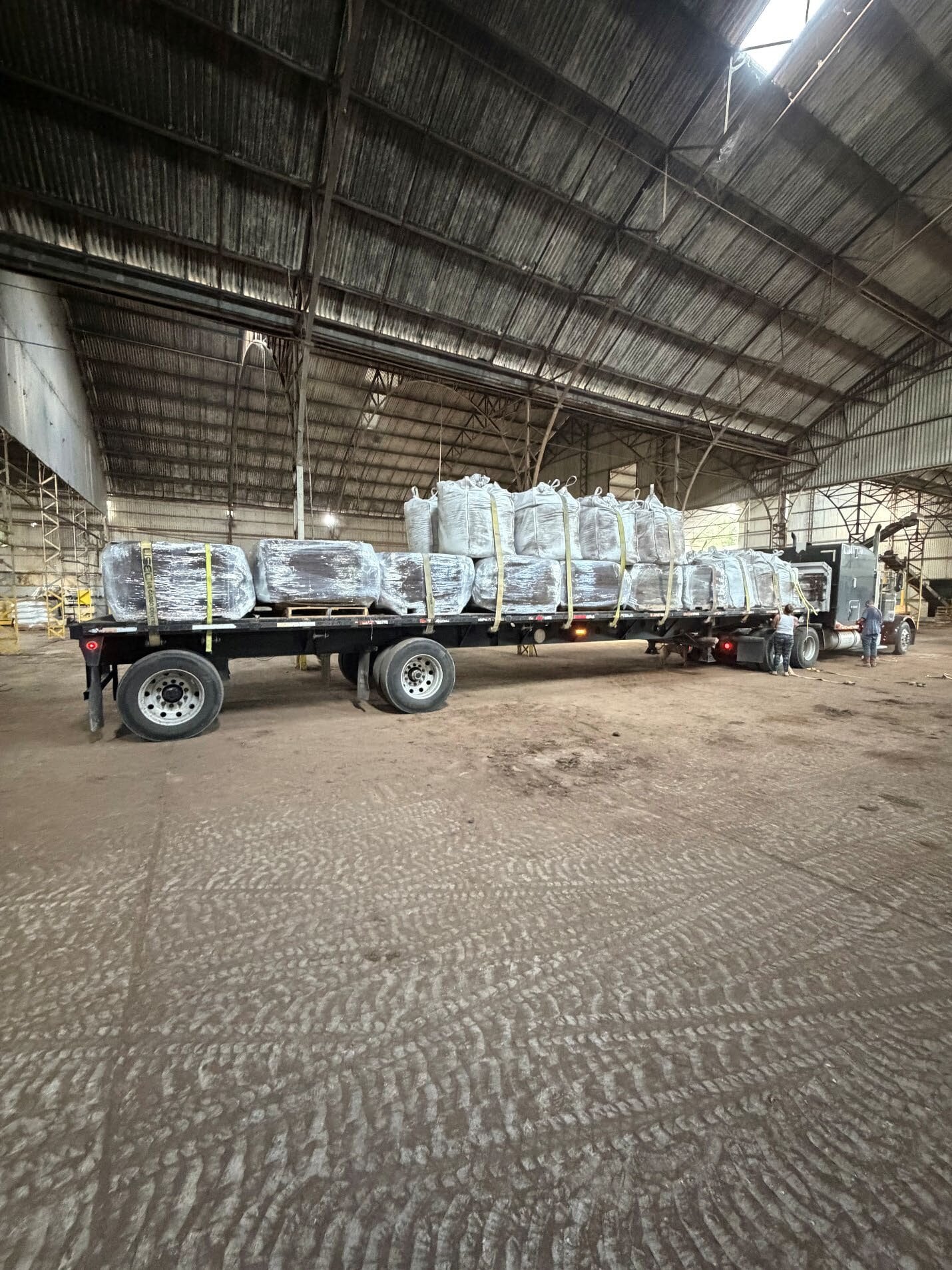 Wrapped SGP+ bales and Super Sacks loaded on a flatbed inside the NPU1 warehouse